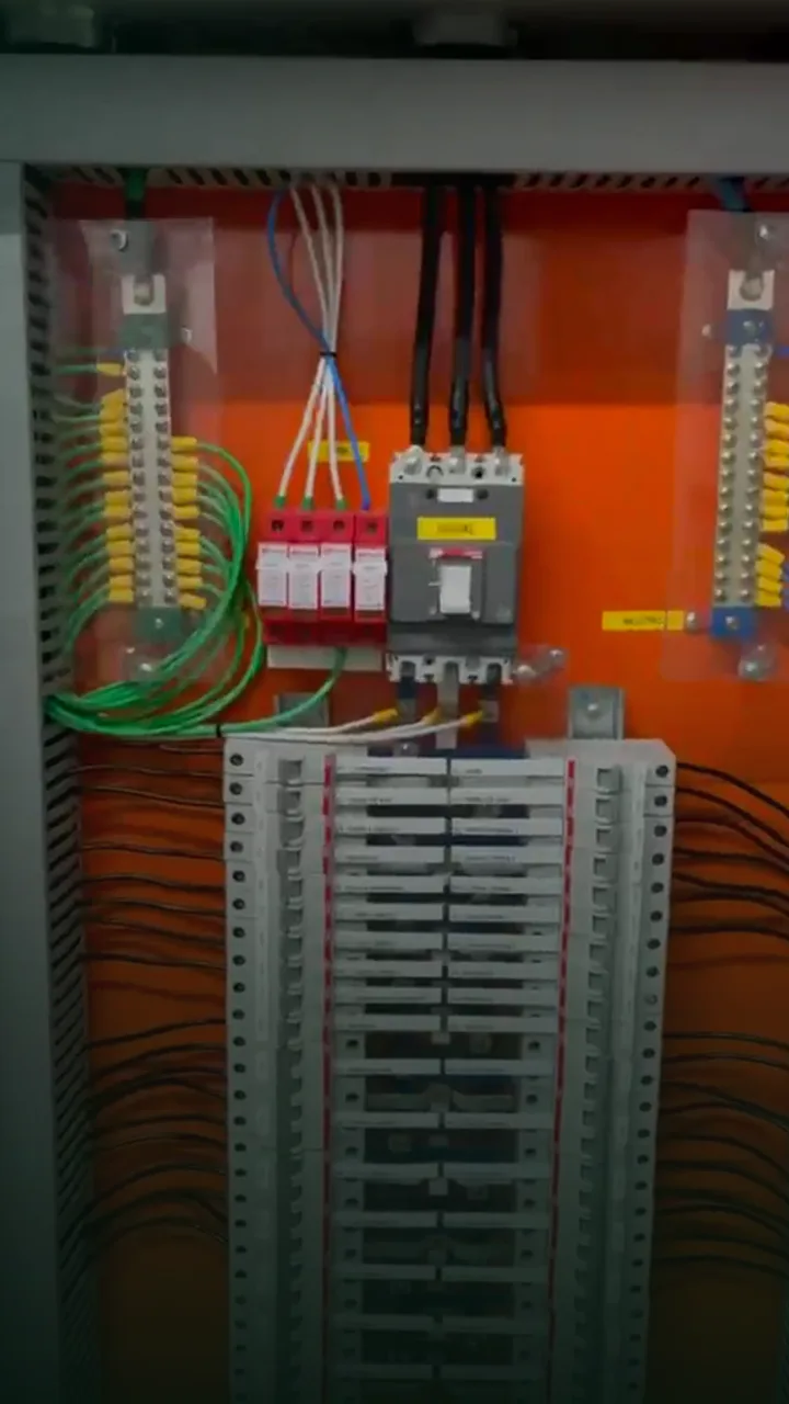 Quadro elétrico aberto com disjuntores organizados e barramentos, durante atendimento